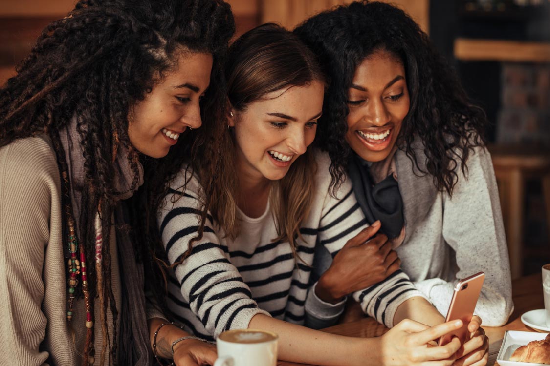 Three friends trying on makeup with Ulta Beauty's augmented reality tool